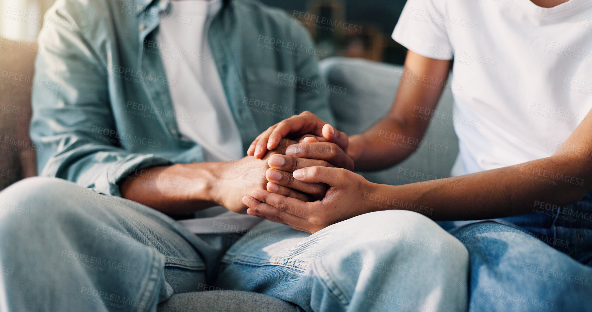 Buy stock photo Couple, holding hands and relax in home for support, consoling and trust in relationship. People, lovers and gesture on living room sofa with empathy, commitment and connection for mental health