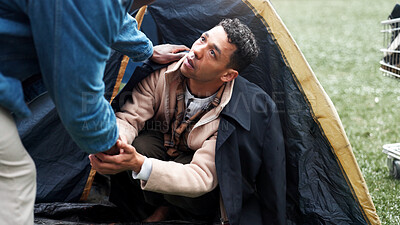 Buy stock photo Man, poverty and homeless with tent, help and holding hands with support, kindness and care on ground. People, volunteer and hope with social awareness, connection and empathy on grass at park