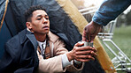 Homeless, hands and person help with money for poverty donation, financial aid or compassion. Tent, beggar and giving coins for empathy, generosity and charity with vulnerability or desperate outdoor