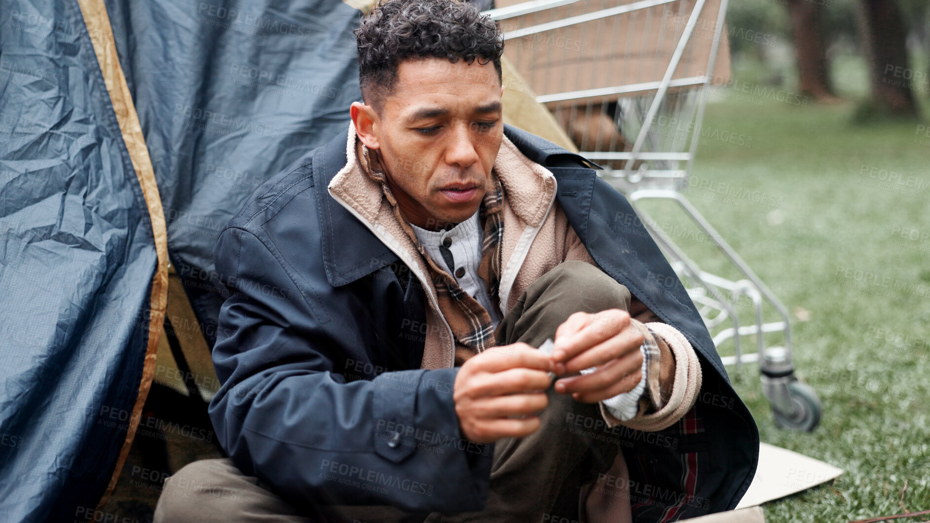Buy stock photo Man, poverty and homeless with drugs at park, package and thinking with illegal product by tent in winter. Person, narcotic substance and chemical for craving, crime and poor with stress in Brazil