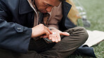 Homeless man, coins and counting at park with poverty, change and donation for food, shelter or support. Person, money and outdoor on ground with financial crisis, begging and poor for help in USA