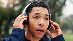 Fitness, man and resting with headphones at park for marathon exercise, breathing and running challenge. Runner, thinking and listening to podcast for workout break, morning jog and relax with audio