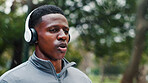 Runner, exercise and man with headphones in rain for training music, breathing and cardio challenge with sound. Wet, black person and listening to podcast for fitness, jog and workout with playlist