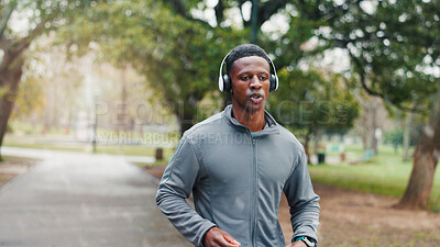 Buy stock photo Fitness, man and running with headphones at park for cardio challenge, breathing and marathon training with music. Black person, athlete and listening to podcast for exercise, morning jog or wellness
