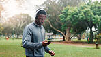 Athlete, man and phone with headphones at park for fitness music, audio playlist and cardio challenge with sound. Black person, runner and streaming service for marathon training, exercise or workout