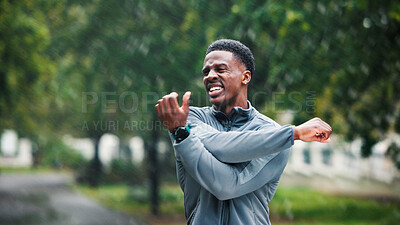 Buy stock photo Fitness, man and stretching outdoor in rain for muscle strength, workout performance and running exercise. Athlete, wet and black person with arm warm up in road for cardio training and getting ready