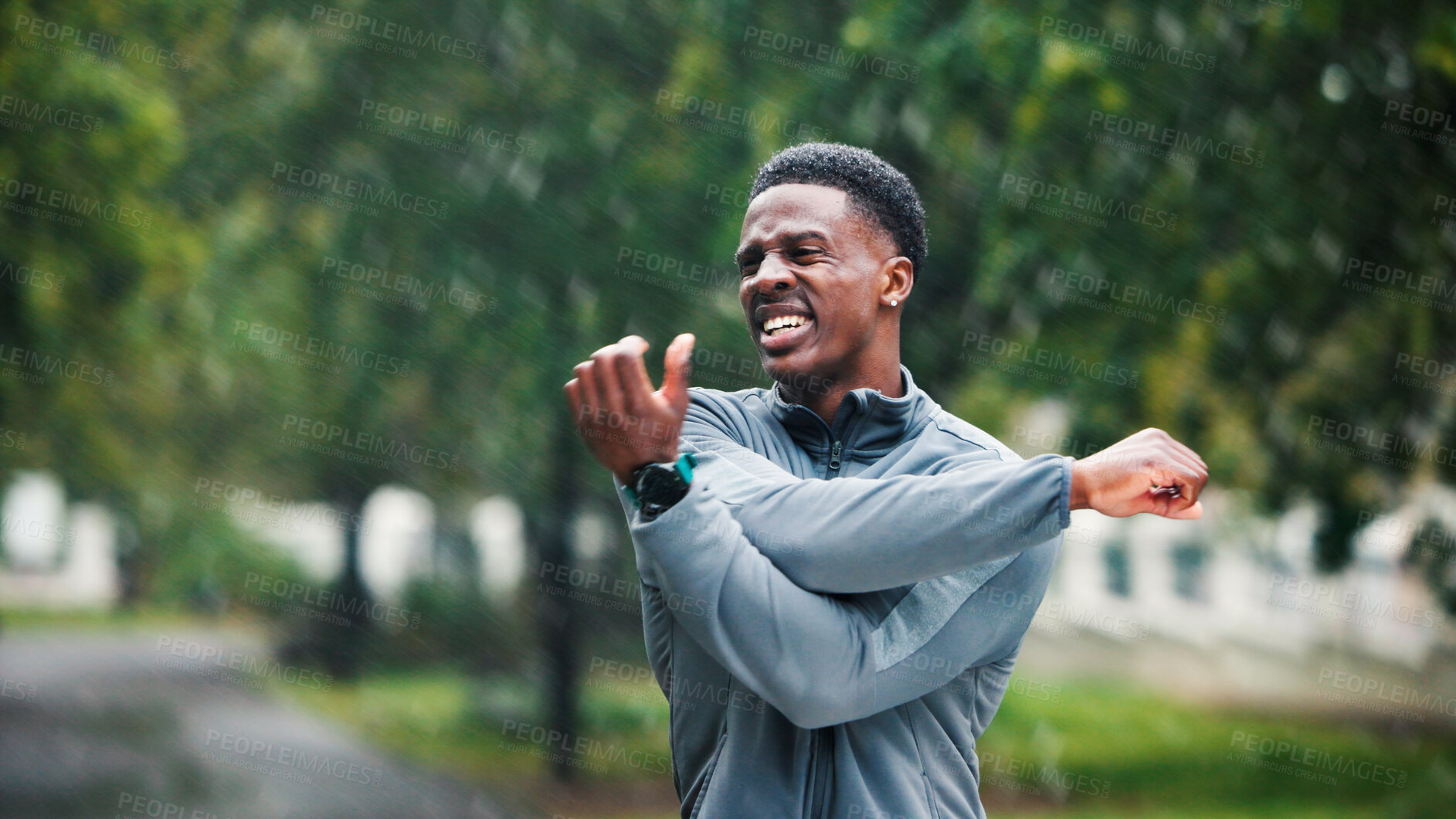Buy stock photo Fitness, man and stretching outdoor in rain for muscle strength, workout performance and running exercise. Athlete, wet and black person with arm warm up in road for cardio training and getting ready