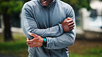 Fitness, nature and man with arm injury, pain or accident on run for marathon, race or training. Sports, exercise and male athlete with muscle sprain, inflammation or tender joint for cardio workout.