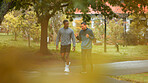 Nature, fitness and men walking in park planning route for cardio workout with marathon training. Sports, conversation and male athletes outdoor in garden for exercise together with activity.