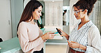 Women, customer and optometrist with pos machine for payment or wireless transaction at optometry store. Female people, client and phone with mobile purchase app for glasses, sight or vision at shop
