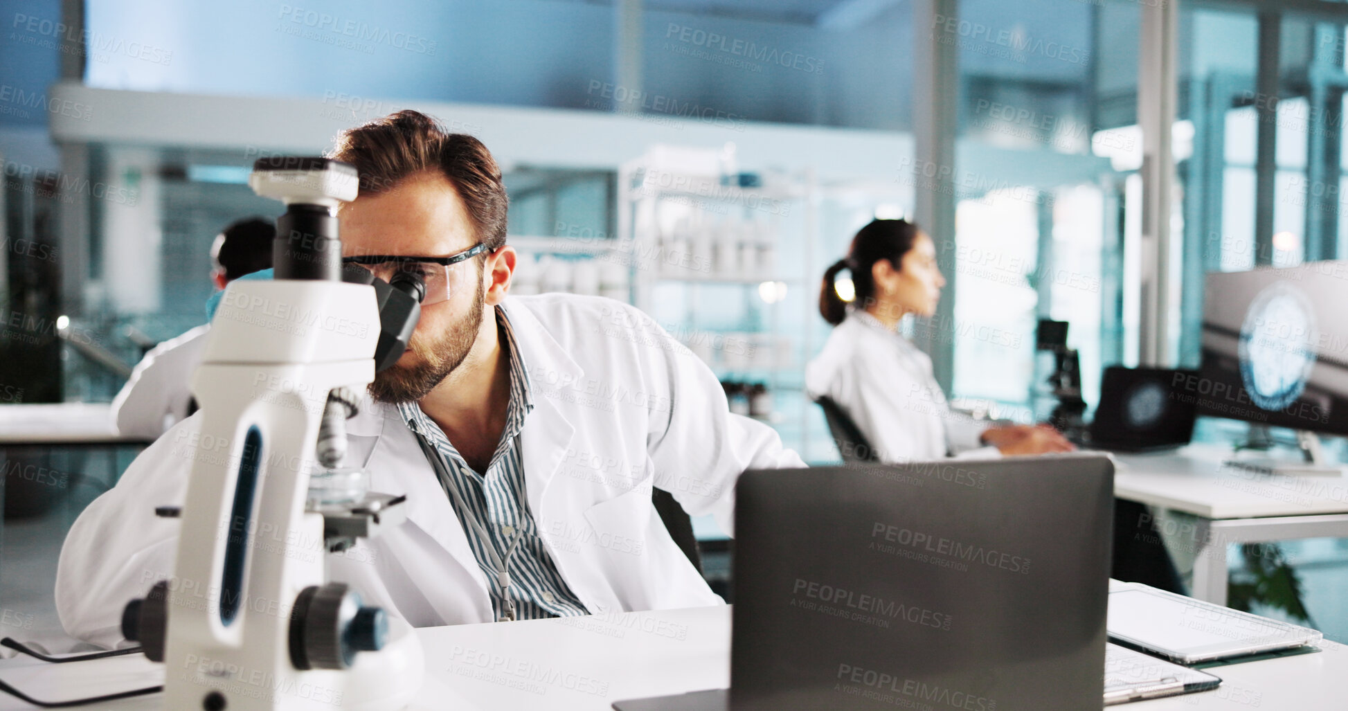 Buy stock photo Scientist, man and microscope with research in laboratory for medical analysis and sample testing. Science, equipment and laptop for vaccine development, biology study and pharmaceutical innovation