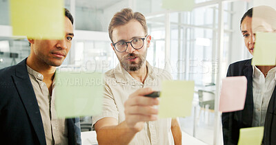 Buy stock photo Business, sticky notes and team with planning by glass wall for advertising campaign, brand management or strategy. Marketing manager, people and discussion for budget development and brainstorming