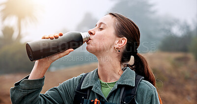 Buy stock photo Thirsty, woman and hiker drinking water in woods on outdoor adventure, hobby or journey. Beverage, hydration and female person with bottle hiking in park for morning exploration, wellness or health