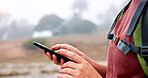 Hands, phone and hiking in nature with search for direction, location and outdoor with scroll by river. Person, smartphone and click on mobile app with digital map, landmark or tourism in countryside