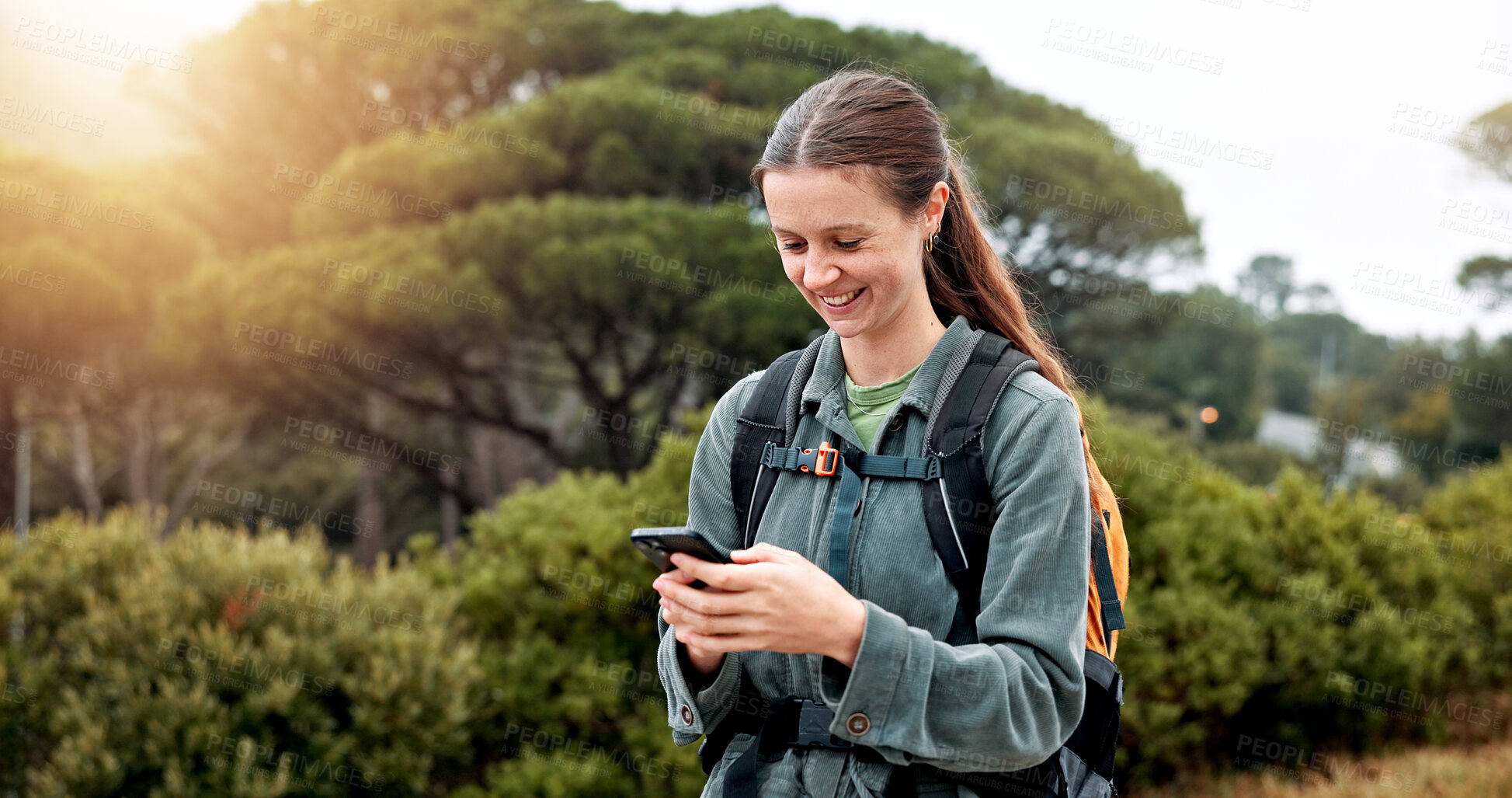 Buy stock photo Girl, hiking and phone in woods, happy and check landmark on map, trail and notification in nature. Person, woman and smartphone on mobile app with search, direction and smile on path in Argentina