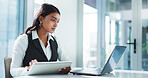 Corporate, serious and woman with laptop, reading and planning for case with info on tablet or lawyer. Law firm, attorney and Indian person with tech for research, legal and review of digital records