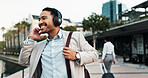 Business, man and happy with headphones outdoor for corporate commute, music playlist and morning radio. Professional, person and smile in city for job opportunity, sound track and walking to work