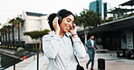 Business, woman and dancing with headphones in city for morning commute, music playlist or streaming audio. Professional, person and happy in city for job opportunity, sound track and travel to work