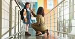 Education, teacher and talking to child, school and care for student with knowledge, hallway and girl. Happy, learner and conversation with woman in elementary, kid and communication with educator