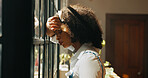African woman, window and anxiety in home with headache, mistake or regret with reflection for decision. Person, sad and thinking for perspective, loss or grief with mental health in morning at house