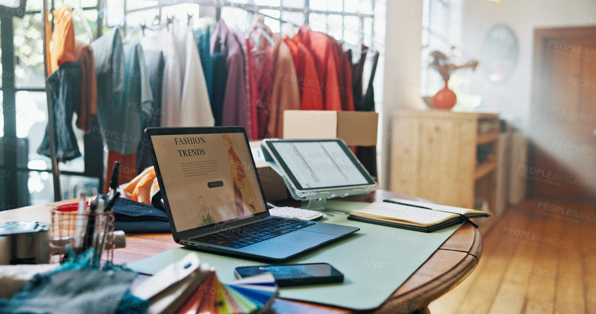 Buy stock photo Empty office, laptop and screen with fashion, clothes and rack on website with research for trends. Workshop, computer and tablet with sample garment, factory and planning for collection in studio