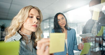 Buy stock photo Business woman, writing and sticky note with team, brand strategist for brainstorming and market research on tablet. People in collaboration, solution and social media project plan with idea on glass