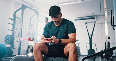 Buy stock photo Phone, healthy and man on break in gym to chat on social media, fitness app or internet. Bodybuilding tips, research and athlete with mobile technology reading workout plan for training or exercise