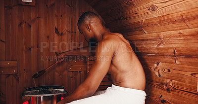 Buy stock photo Sauna, fitness and hot stones with black man in gym for muscle recovery, post workout and health in sports center. Detox therapy, athlete cramp and wellness with person in steam room for sweating
