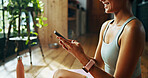 Home, woman and fitness with mobile for chat, check message and workout video on social media. House, happy person and connection with smartphone for application, exercise tips and streaming website