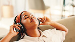 Relax, happy woman and listening to music in living room with podcast, audiobook or sound. African person, home and headphones for streaming radio, subscription or favorite song for peace or calm