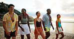Smile, holiday and friends walking on beach for vacation or summer trip on tropical island together at sunset. Group, tourism and people at ocean for relax, travel and laughing on adventure at sea