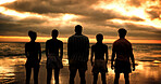 Group, back and friends at sunset, beach and together with solidarity, nature or reunion on vacation in summer. People, outdoor and clouds at dusk, waves and connection on holiday for memory by ocean