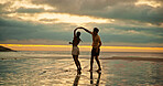 Couple, dance and holding hands with spin on beach of travel date, romance and sunset of summer holiday. People, play and bonding on vacation trip, tropical island and partner commitment for getaway 