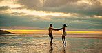 Couple, holding hands and spin for fun on beach for travel date, energy and sunset of summer holiday. People, playful and romantic for vacation trip, tropical island and partner commitment of getaway