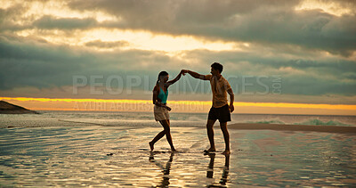 Buy stock photo Couple, dance and holding hands for fun on beach of travel date, romance and sunset of summer holiday. People, playful and bonding on vacation trip, tropical island and partner commitment of getaway 