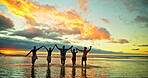 Sunset, holding hands and friends in sea water for vacation, holiday and summer trip on tropical island. Group, ocean and people in celebration by beach for travel, adventure and freedom at dusk