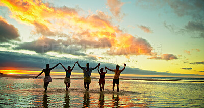 Buy stock photo Sunset, holding hands and friends in sea water for vacation, holiday and summer trip on tropical island. Group, ocean and people in celebration by beach for travel, adventure and freedom at dusk
