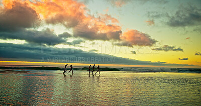 Buy stock photo Sunset, people running and friends in sea water for holiday, vacation and summer trip on tropical island. Group, ocean and race by beach with freedom for travel, adventure and energy with space