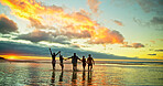 Sunset, holding hands and friends in ocean water for vacation, holiday and summer trip on tropical island. Group, sea and people running by beach for travel, adventure and celebrate freedom at dusk