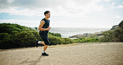Buy stock photo Ocean, running and man in street, fitness and sports with cardio, workout and challenge. View, person and runner with exercise, outdoor and energy with wellness, practice and healthy with training