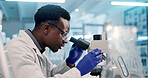 Microscope, black man and scientist in laboratory for medical research, discovery or project on organisms. Biotechnology, goggles and African biologist with equipment for DNA review for innovation.