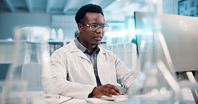 Buy stock photo Computer, reading and man in laboratory for research, development or science ideas. Online analytics, vaccine and African scientist on website for medical study, innovation and biotech engineering