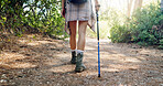 Hiking, walking and legs of person in nature for adventure, trekking and travel outdoors. Forest, fitness and person with stick for wellness, fresh air and exercise to explore on holiday and vacation
