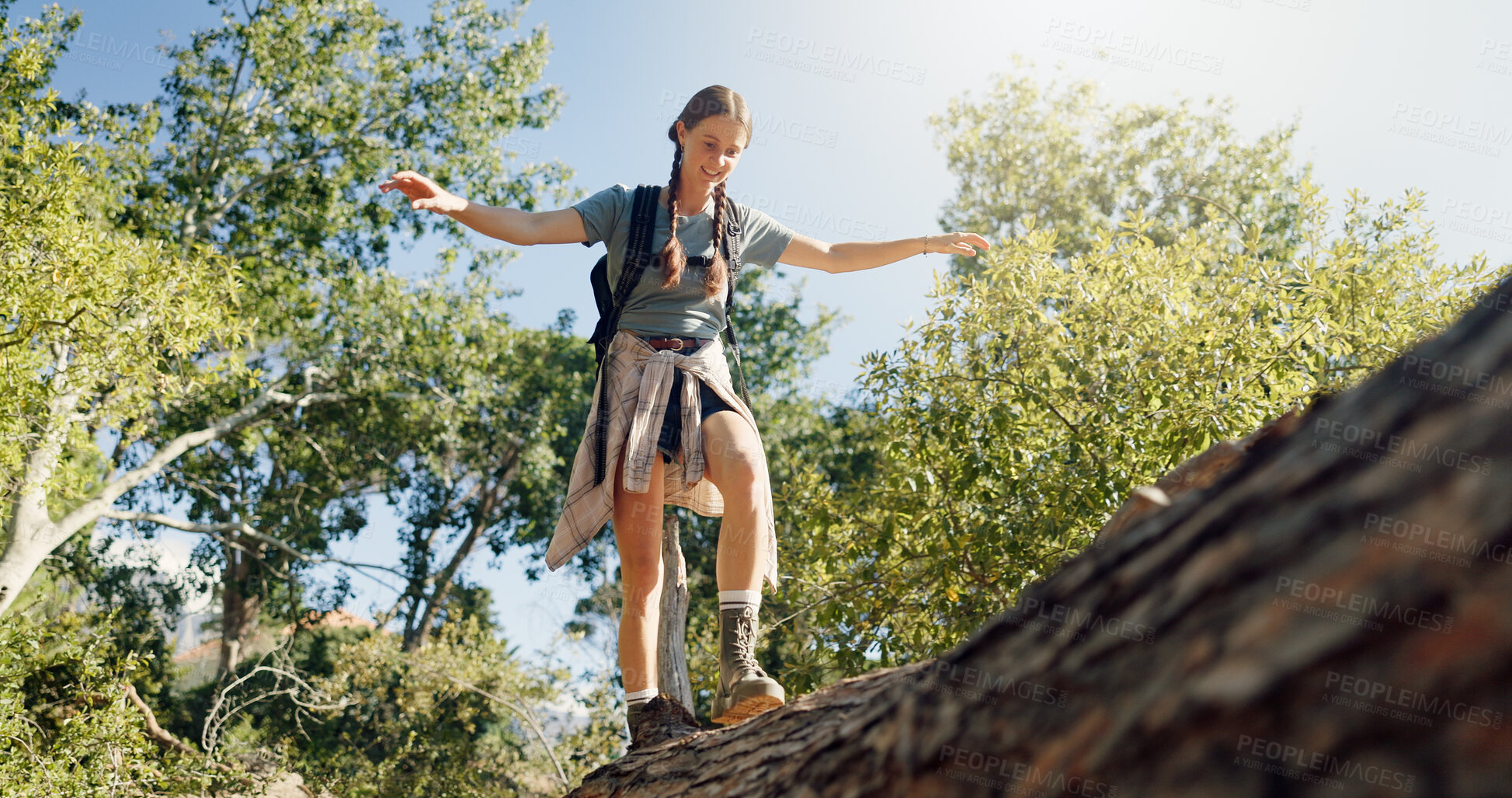 Buy stock photo Happy woman, hiker and walking with balance on log for trekking adventure, extreme path or trail in nature. Female person, low angle or tree bridge with smile for exploration, journey or outdoor trip