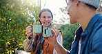 Outdoor, camping and couple with coffee, cheers and bonding with warm beverage in nature or adventure. Hiking, travel and people with hot tea for cold weather, toast or tourists with love in vacation