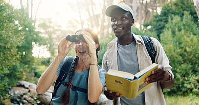 Buy stock photo Binoculars, travel and couple with birdwatching in forest, book for info and knowledge of species in nature. Surprise, people and view with sightseeing, hiking and trekking with animal text in woods