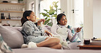 Watching tv, women and friends with phone, relax and bonding with reality show, smile and entertainment. Home, girls and people with mobile app to change channel, together and streaming of movies