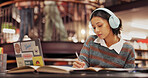 Studying, student and woman with headphones, library and listening to music for project and education. College, writing and girl with notes for knowledge, scholarship and streaming playlist with tech
