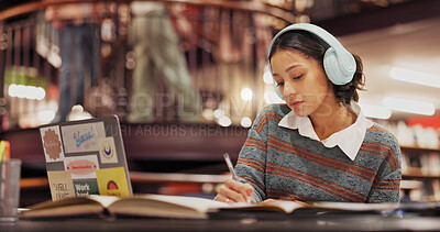 Buy stock photo Studying, student and woman with headphones, library and listening to music for project and education. College, writing and girl with notes for knowledge, scholarship and streaming playlist with tech