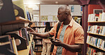 Phone, student and study with black man in library to search for books or research material. App, learning and social media with African person on college or university campus for school scholarship